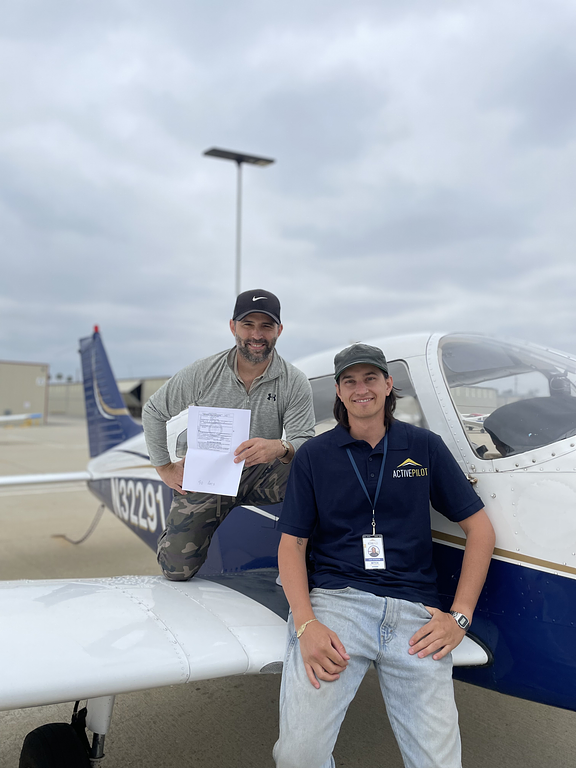 Mitch Rittenhouse with student Steve holding a private pilot certificate